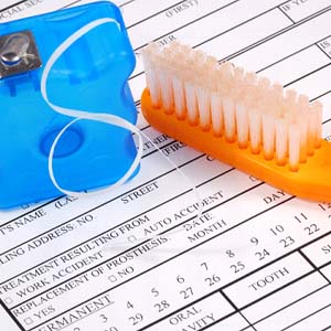 Toothbrush and floss resting on a dental insurance form