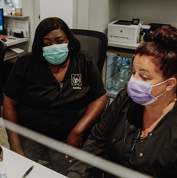 Two dental team members reviewing patient paperwork