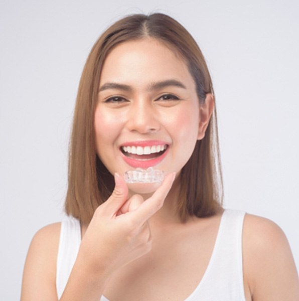 a patient holding her clear aligner in Jacksonville, FL