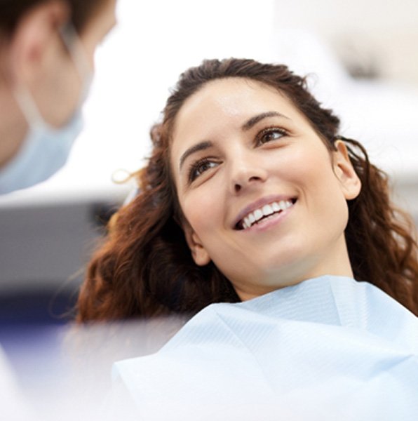 A smiling woman looking at her dentist 