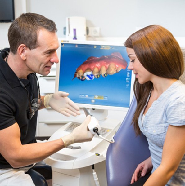 Dentist and patient talking about digital impression scanner