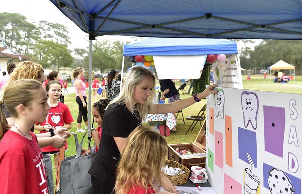 Dental team member working with kids at a community event