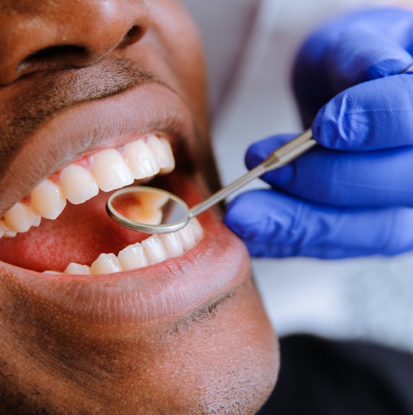 Dentist examining patient's smiles after metal free dental crowns
