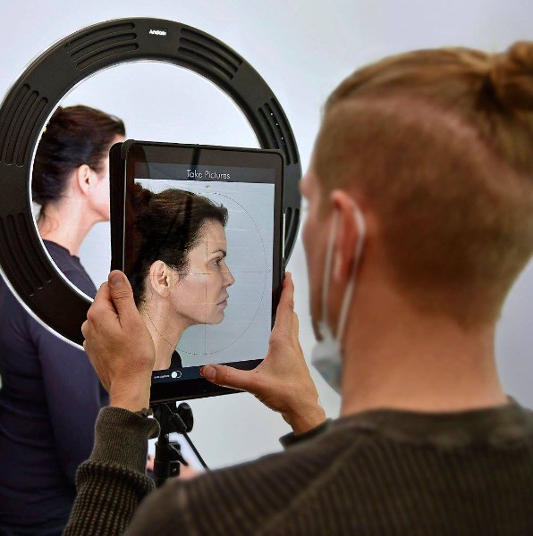 Dental team member taking images for a virtual smile design