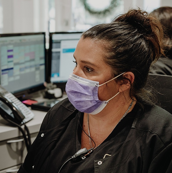 Dental team member scheduling a patient for emergency dentistry