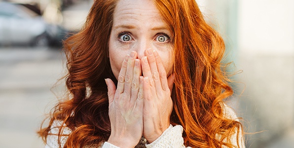 Woman with knocked out tooth covering her mouth