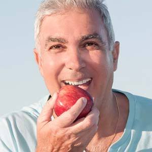 Middle-aged man biting into a red apple