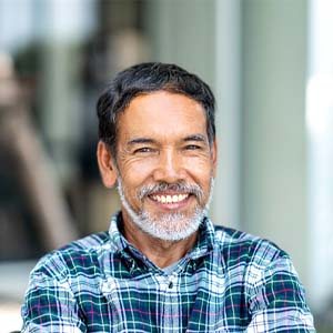 Man in plaid shirt smiling outside