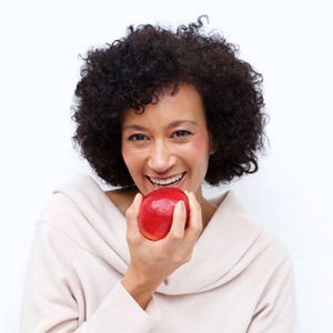 woman biting into a red apple 