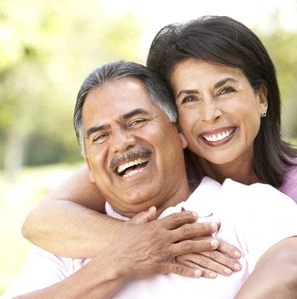 Smiling couple with implant dentures in Jacksonville