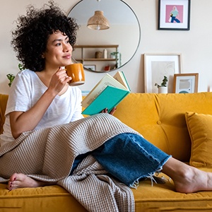 a woman relaxing on a couch with a book