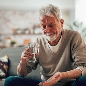 a man taking a pill with water