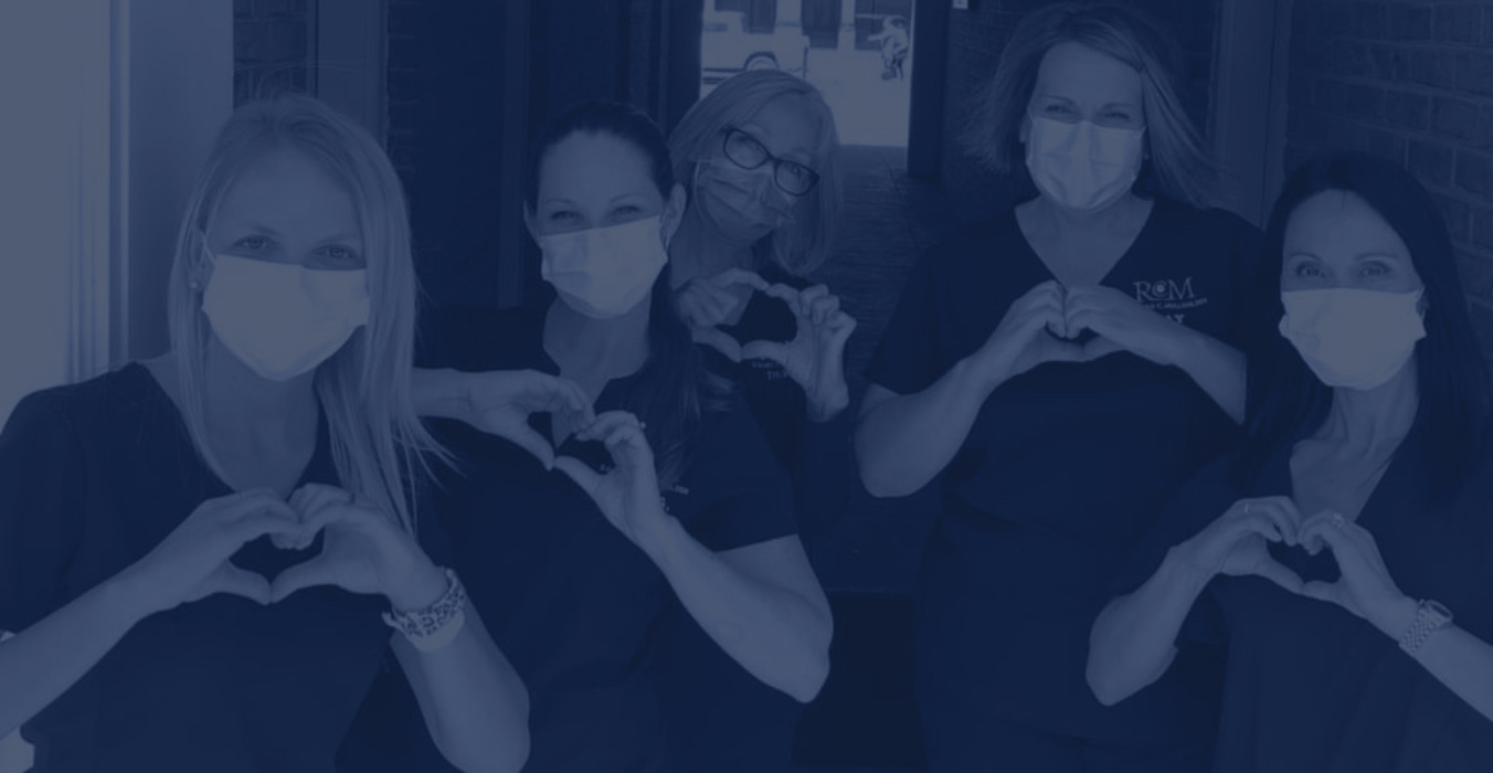 Smiling Jacksonville dental team members making hearts with their hands