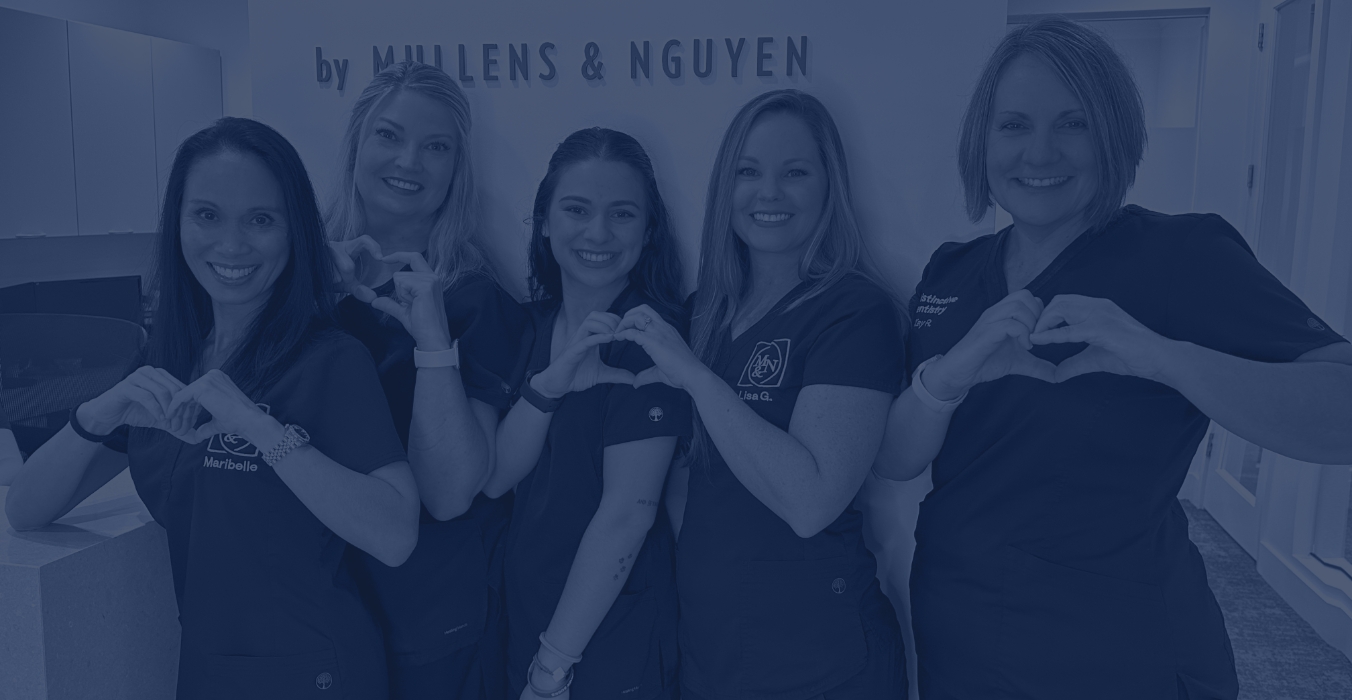 Smiling Jacksonville dental team members making hearts with their hands