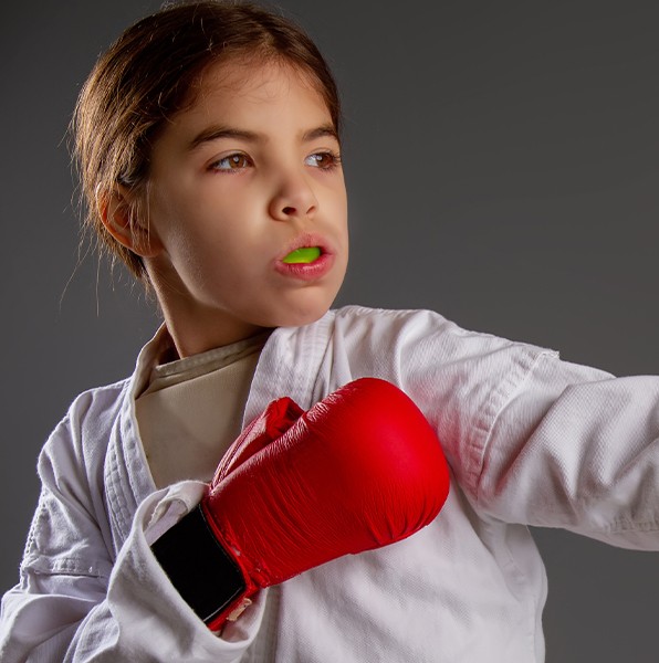 Young girl wearing a green athletic mouthguard