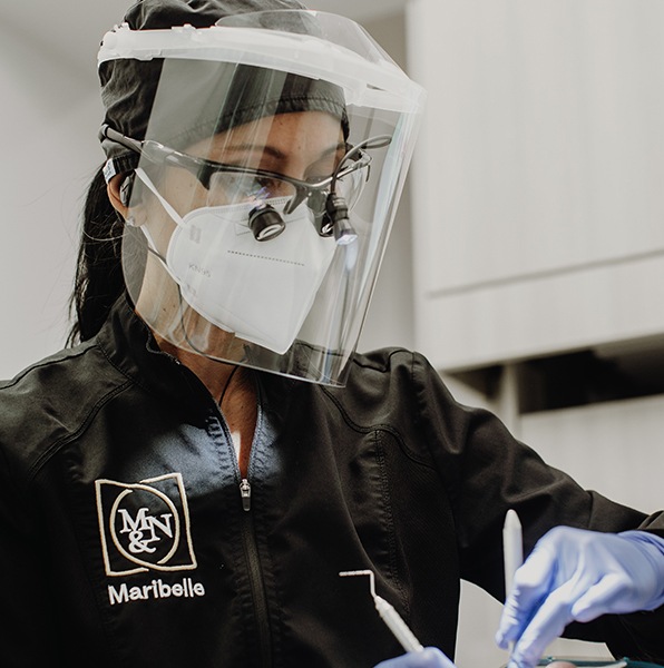 Dental team member examining patient during preventive dentistry exam and teeth cleaning