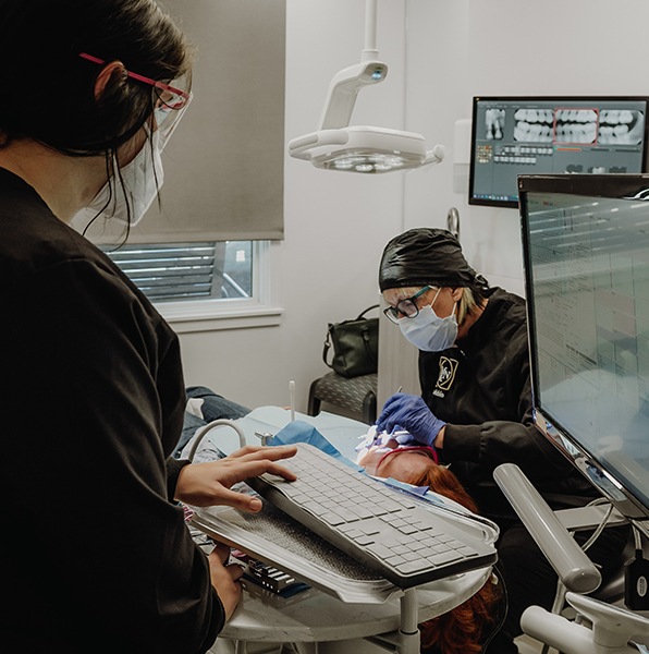 Dentist performing soft tissue laser dentistry treatment