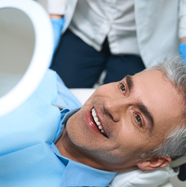 man admiring his new porcelain veneers in Jacksonville