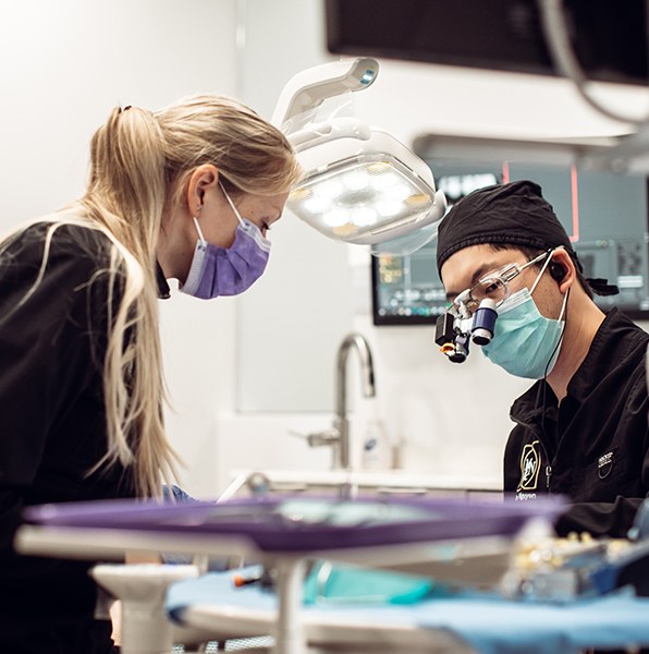 Dentist and team member performing wisdom tooth extraction